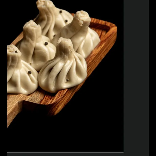 Hot steamed Georgian khinkali dumplings on a wooden board